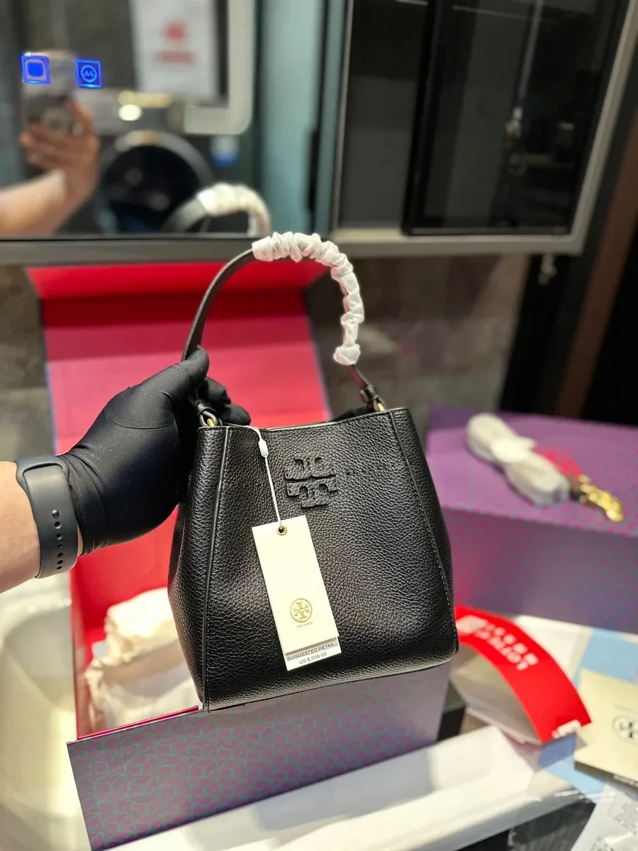 Black bucket-shaped handbag with a top handle and tonal logo