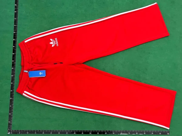 Red three-stripe trousers shown in the linked Adidas catalog listing
